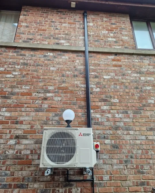 an air conditioner mounted to a brick wall