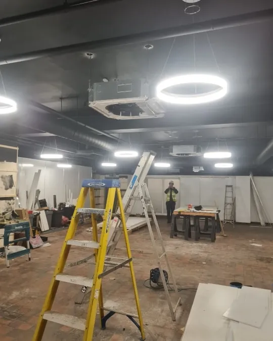 a man standing on a ladder in a room