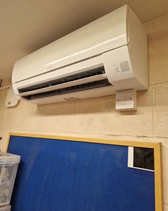 a white air conditioner sitting on top of a wall