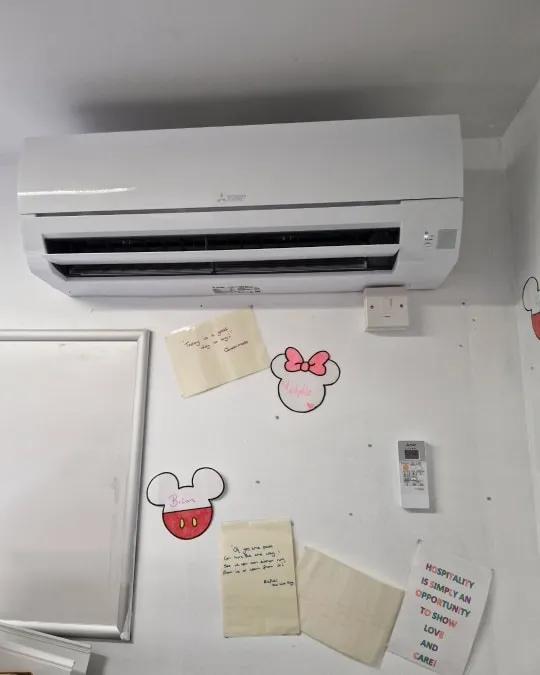 a white air conditioner sitting on top of a white wall